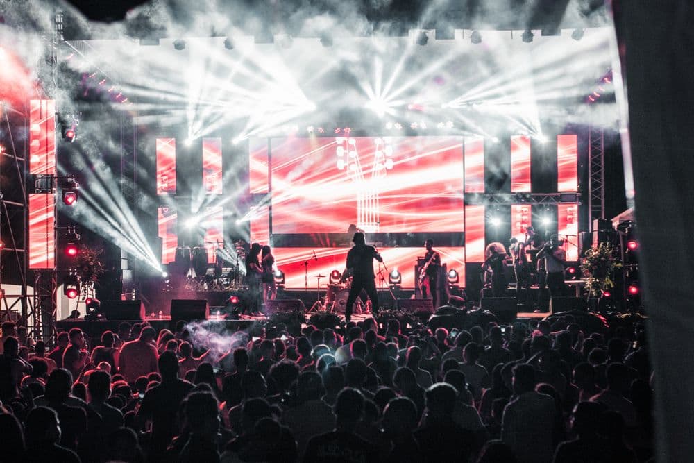 A band on a blazing concert stage in front of a huge crowd